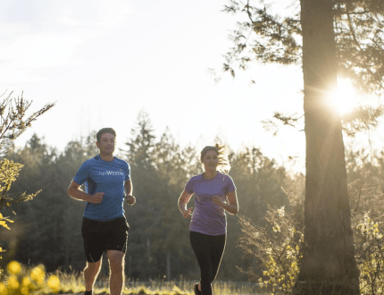 two people running in the woods