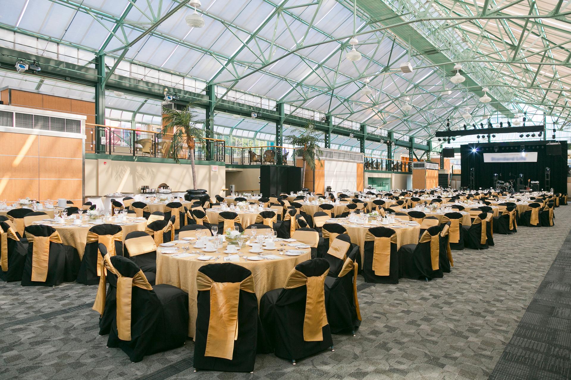 A spacious indoor event featuring neatly arranged tables and chairs for guests to gather and enjoy